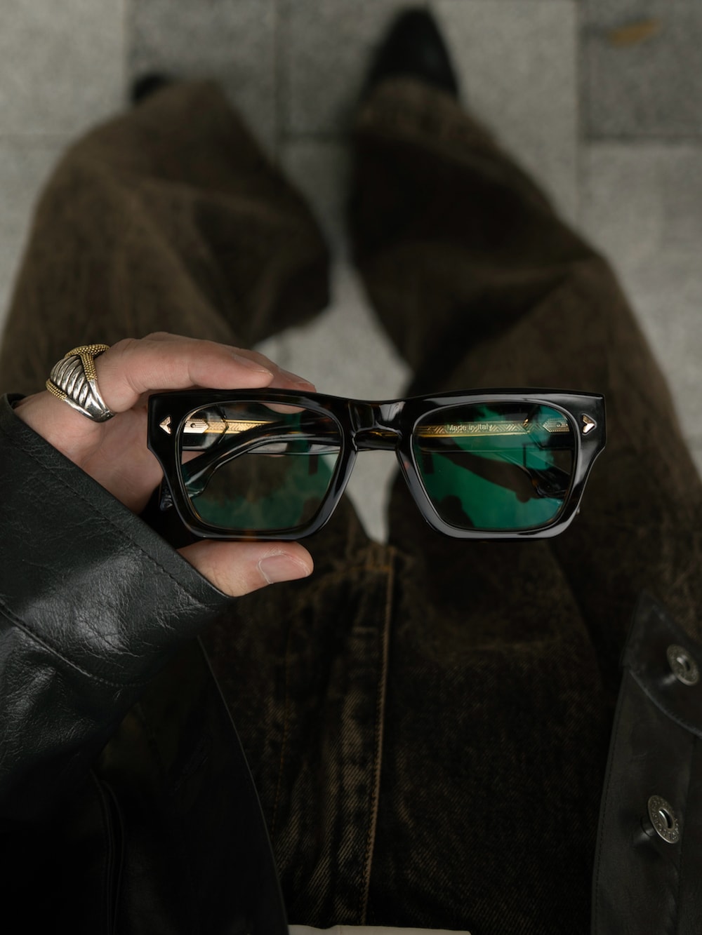 ブラック系のその他アウター、ブラウン系のデニムパンツを着用したメンズの秋コーディネートの3枚目の写真