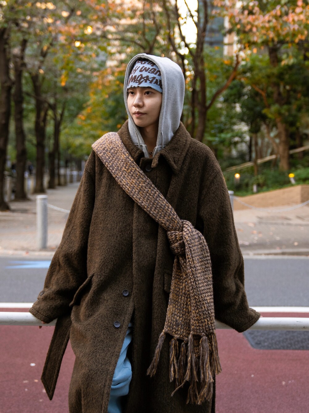 ブラック系のステンカラーコート、ベージュ系のその他パンツ、グレー系のパーカーを着用したメンズの秋コーディネートの2枚目の写真