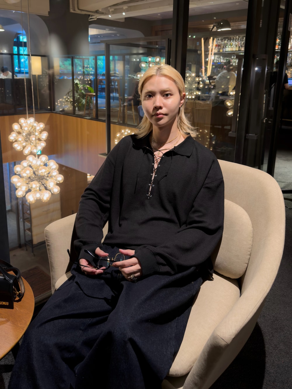 ブルー系のデニムパンツ、ブラック系のハンドバッグ、ブラック系のドレスシューズを着用したメンズの夏コーディネートの2枚目の写真