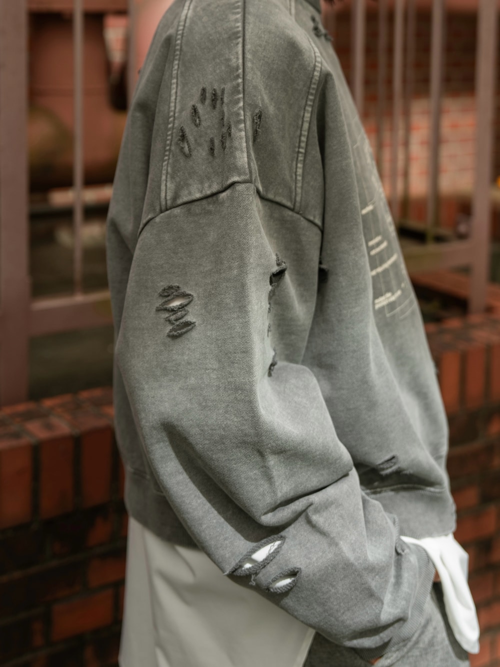 グレー系のスウェット、グレー系のデニムパンツを着用したメンズの秋コーディネートの5枚目の写真