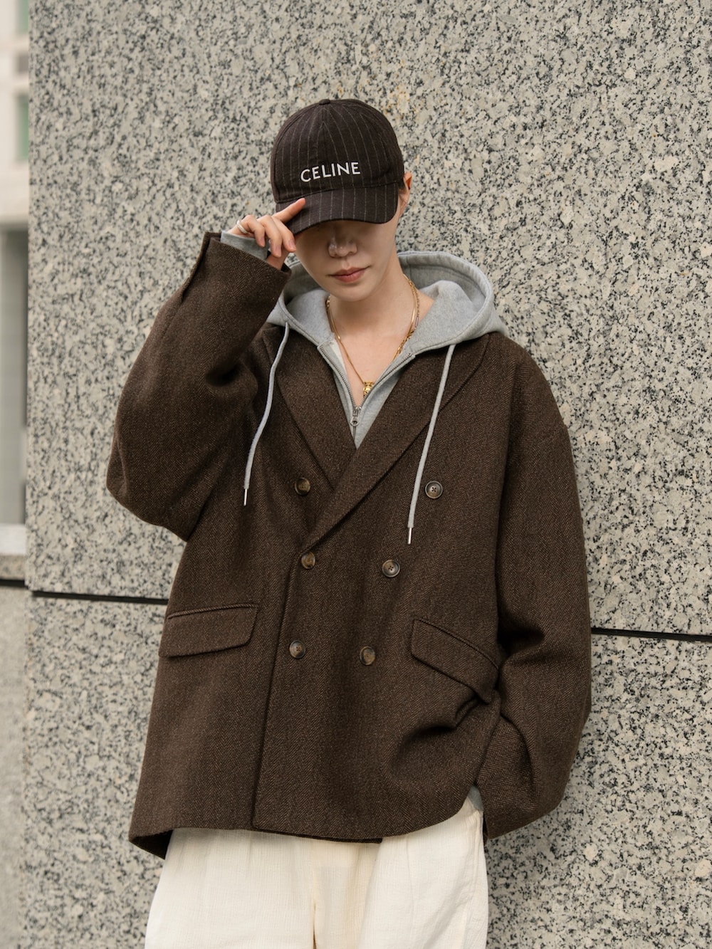 グレー系のパーカー、ブラウン系のテーラードジャケット、ホワイト系のその他パンツを着用したメンズの秋コーディネートの4枚目の写真