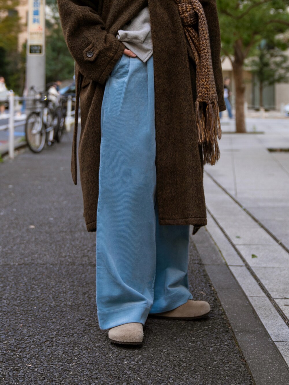 ブラック系のステンカラーコート、ベージュ系のその他パンツ、グレー系のパーカーを着用したメンズの秋コーディネートの3枚目の写真