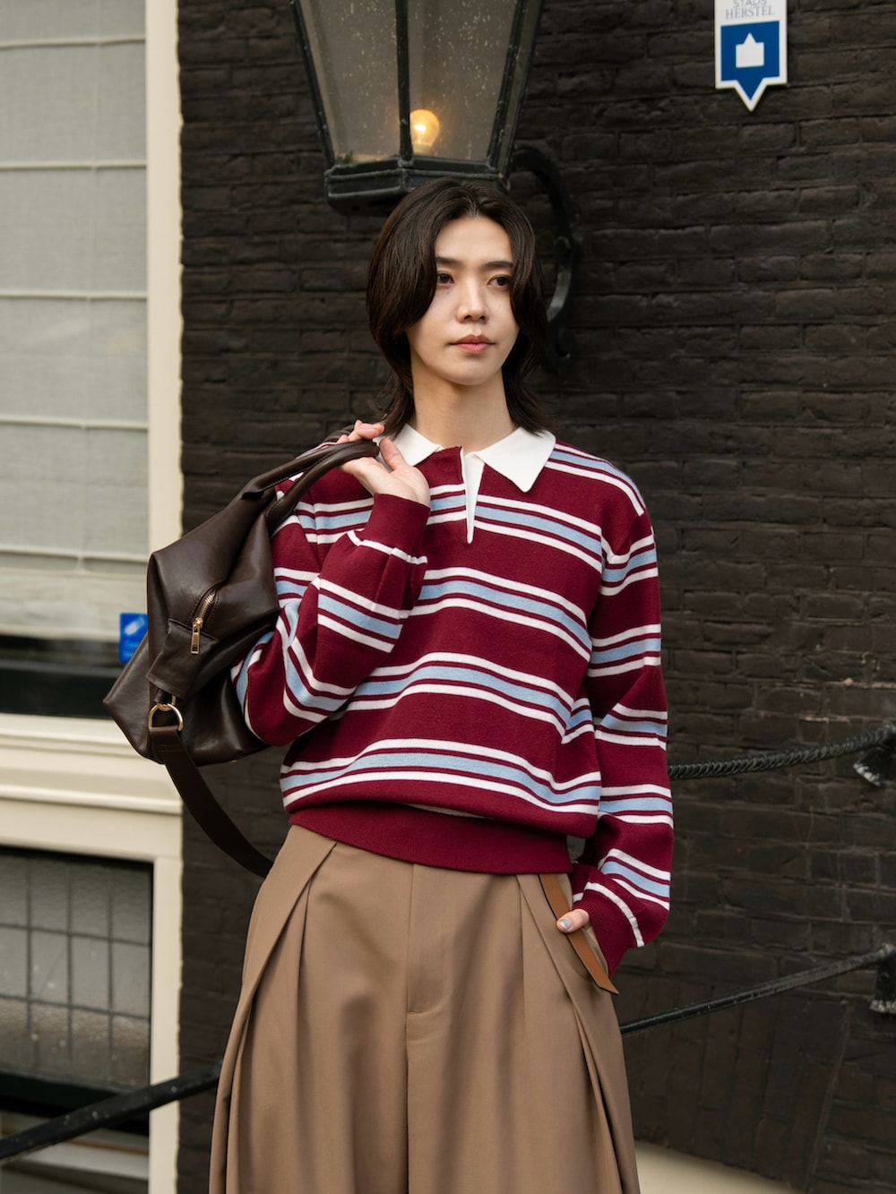 レッド系のポロシャツ、ブラウン系のスラックスを着用したメンズの秋コーディネートの4枚目の写真