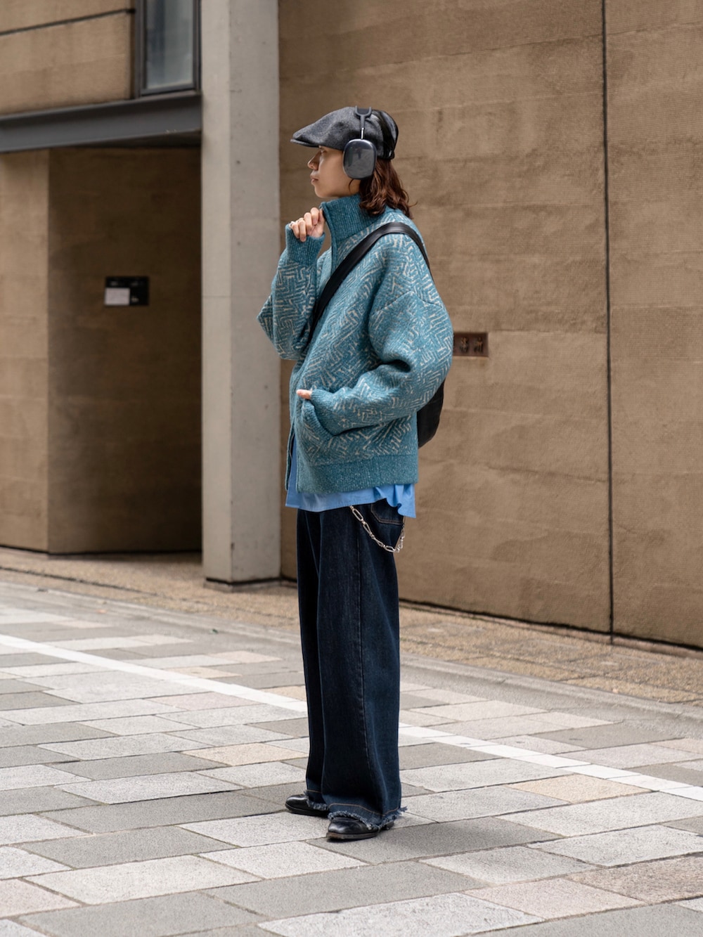 ベージュ系のニット/セーター、ブルー系のデニムパンツ、ブラック系のハンチング/ベレー帽を着用したメンズの秋コーディネートの4枚目の写真