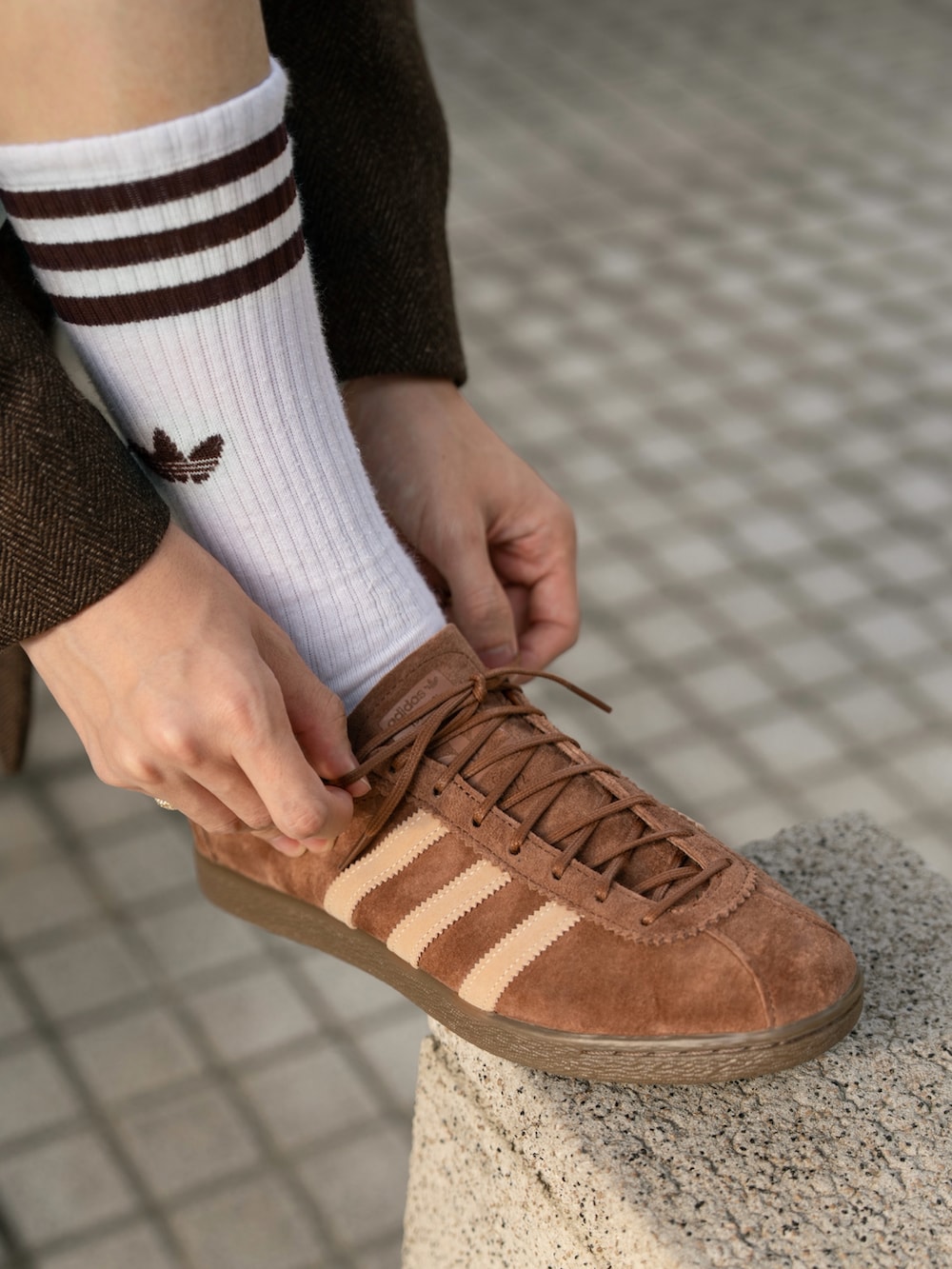 グレー系のパーカー、ブラウン系のテーラードジャケット、ホワイト系のその他パンツを着用したメンズの秋コーディネートの3枚目の写真