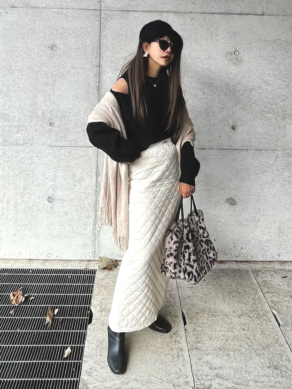 ブラック系のニット/セーター、ホワイト系のスカート、シルバー系のネックレスを着用したレディースの冬コーディネートの2枚目の写真