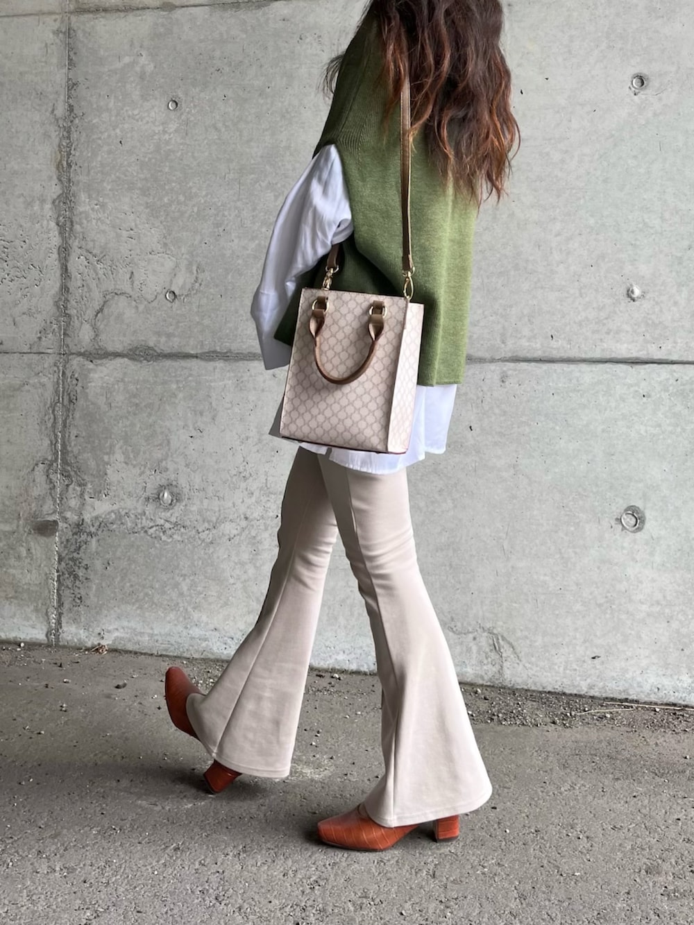 グリーン系のベスト、ベージュ系のその他パンツ、ブラウン系のパンプスを着用したレディースの冬コーディネートの2枚目の写真