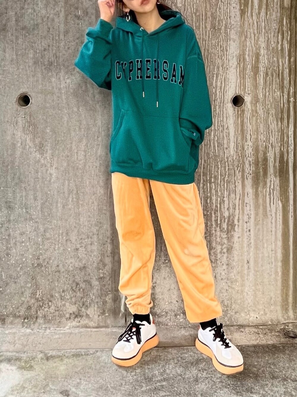 グリーン系のパーカー、ベージュ系のその他パンツ、ホワイト系のスニーカーを着用したレディースの冬コーディネートの3枚目の写真