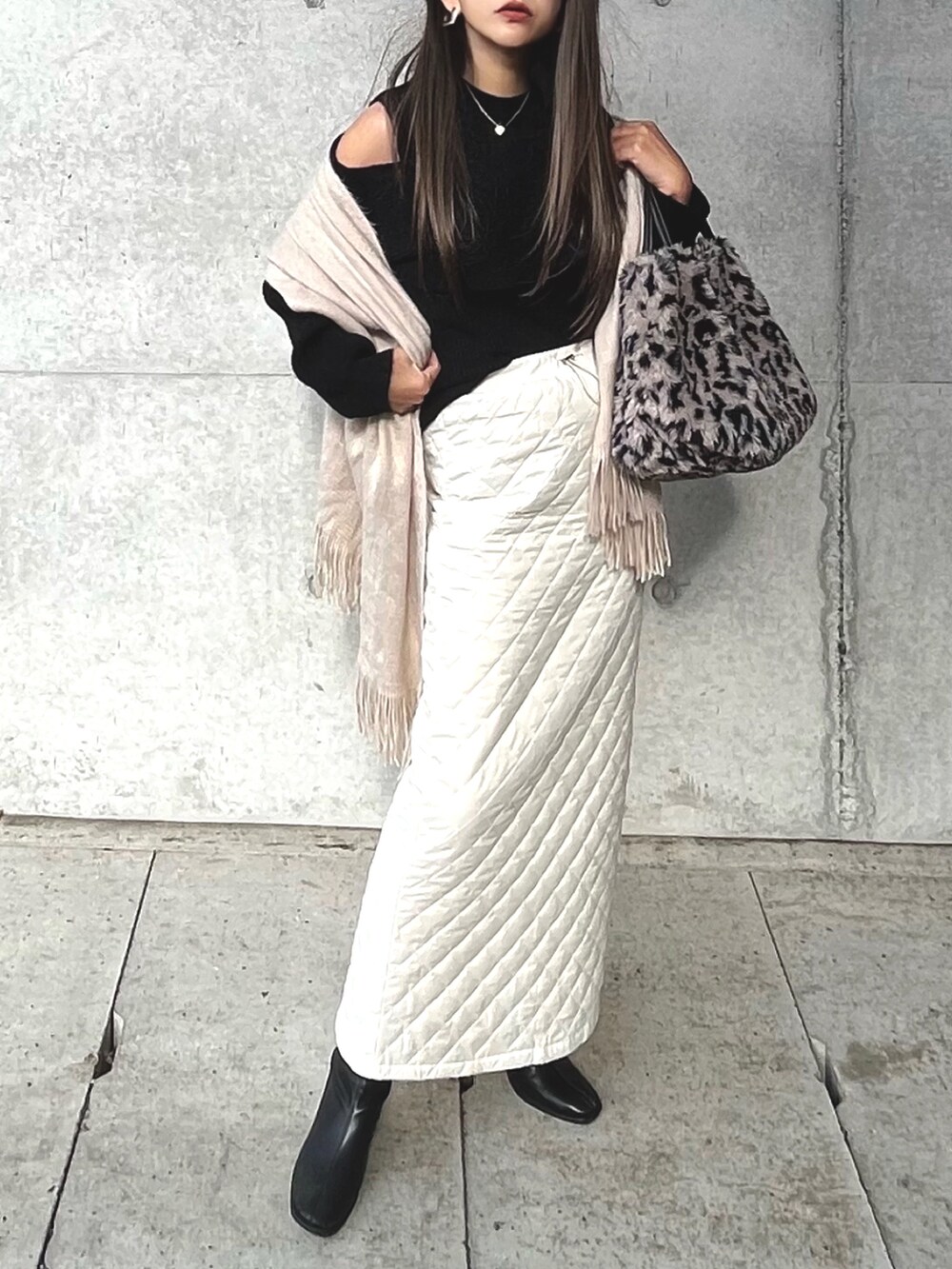 ブラック系のニット/セーター、ホワイト系のスカート、シルバー系のネックレスを着用したレディースの冬コーディネートの3枚目の写真