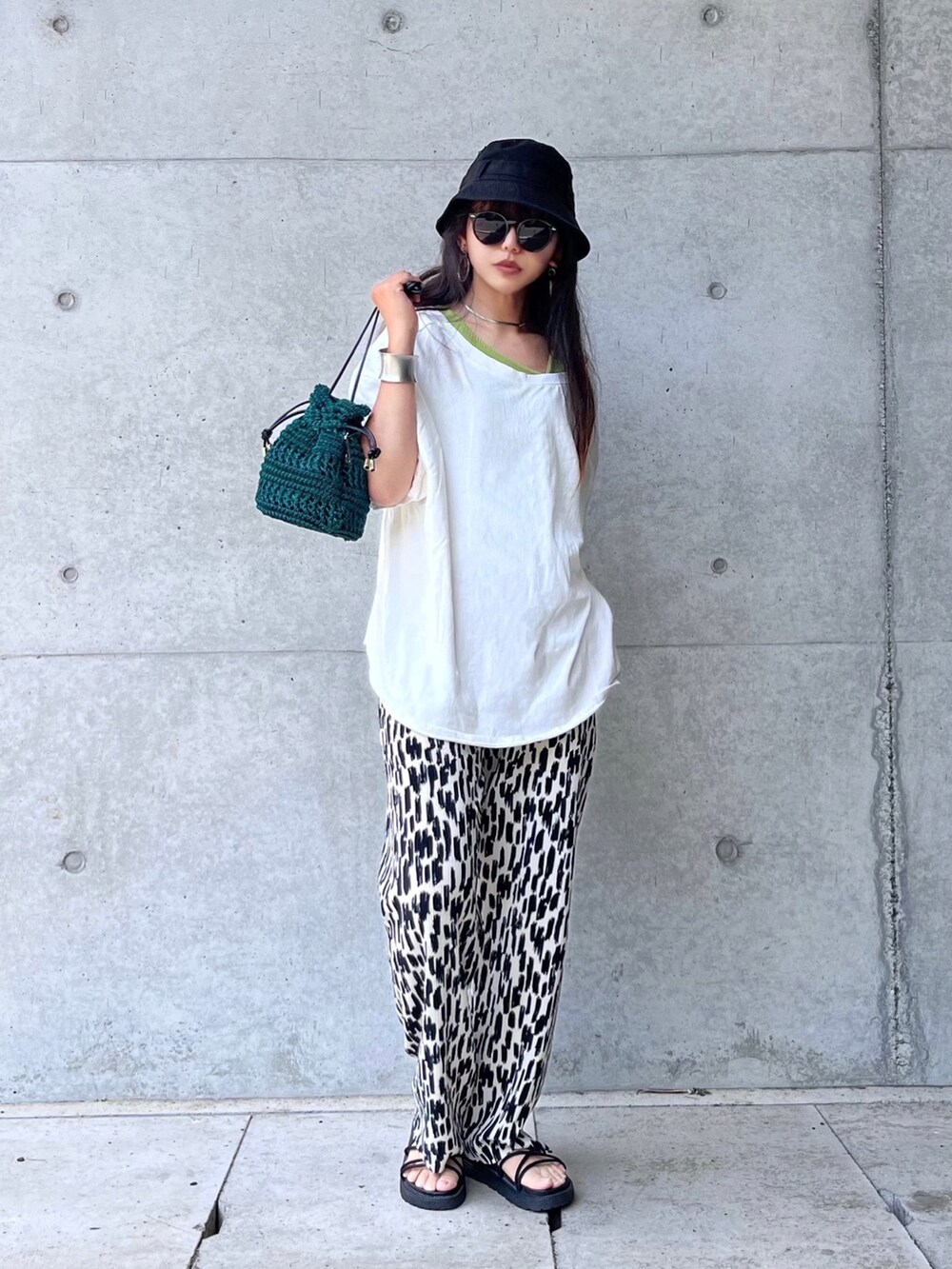 ホワイト系のその他パンツ、グリーン系のバッグ、ホワイト系のTシャツ/カットソーを着用したレディースの夏コーディネートの2枚目の写真