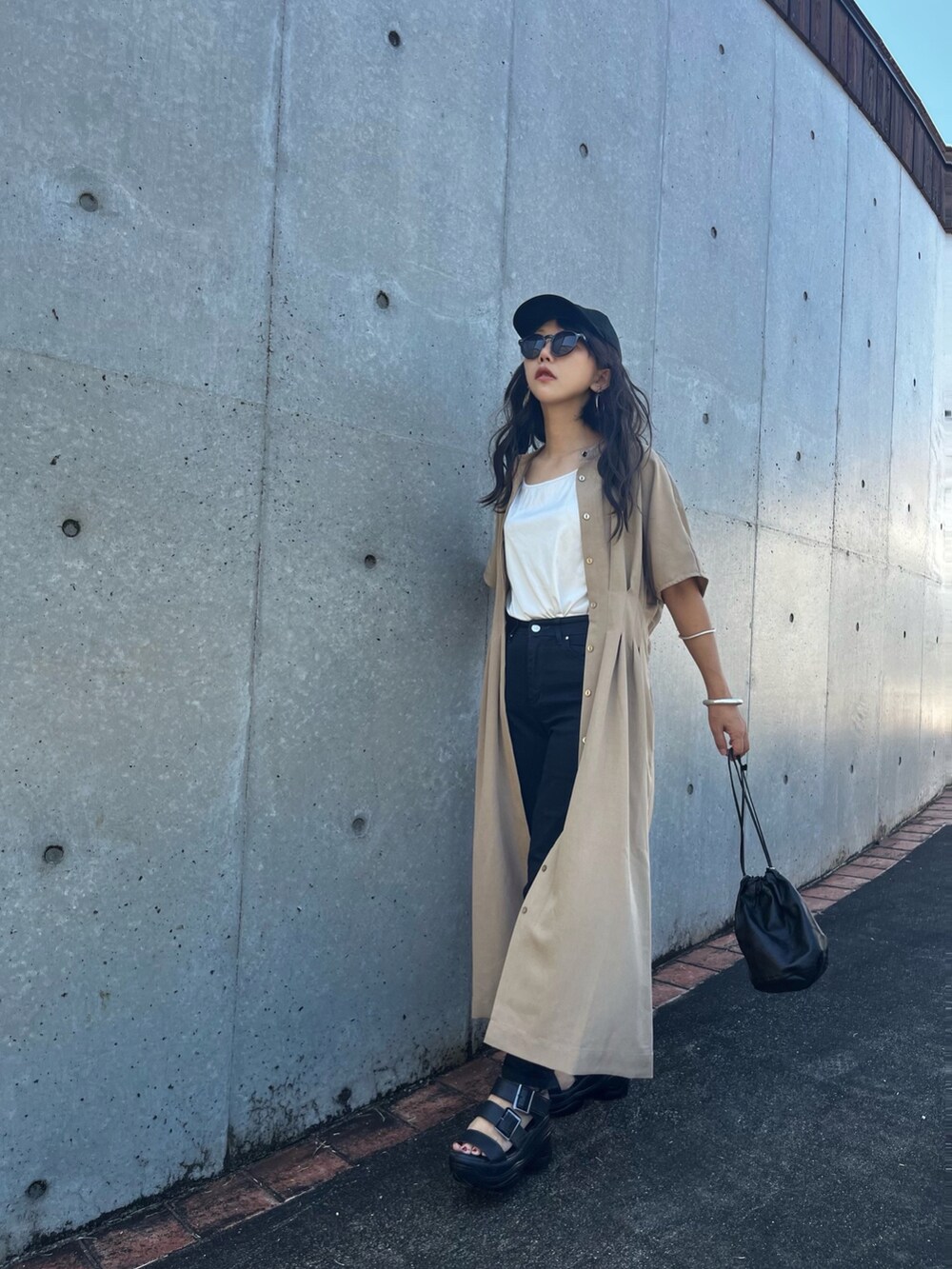 ベージュ系のワンピース、ブラック系のデニムパンツ、ブラック系のサンダルを着用したレディースの夏コーディネートの3枚目の写真