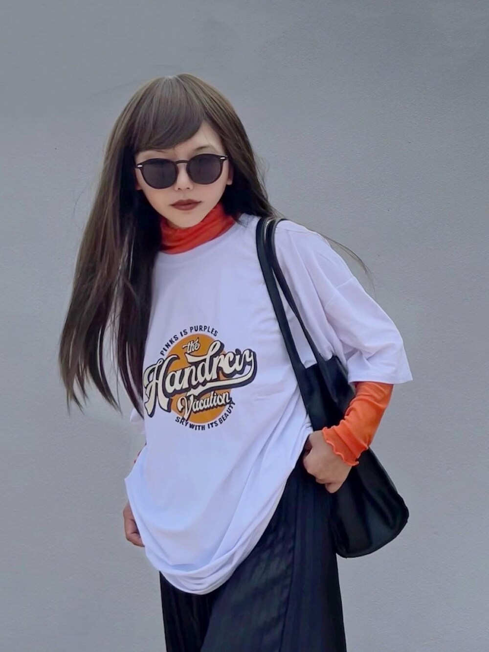 ホワイト系のTシャツ/カットソー、オレンジ系のTシャツ/カットソー、ブラック系のサンダルを着用したレディースの秋コーディネートの4枚目の写真