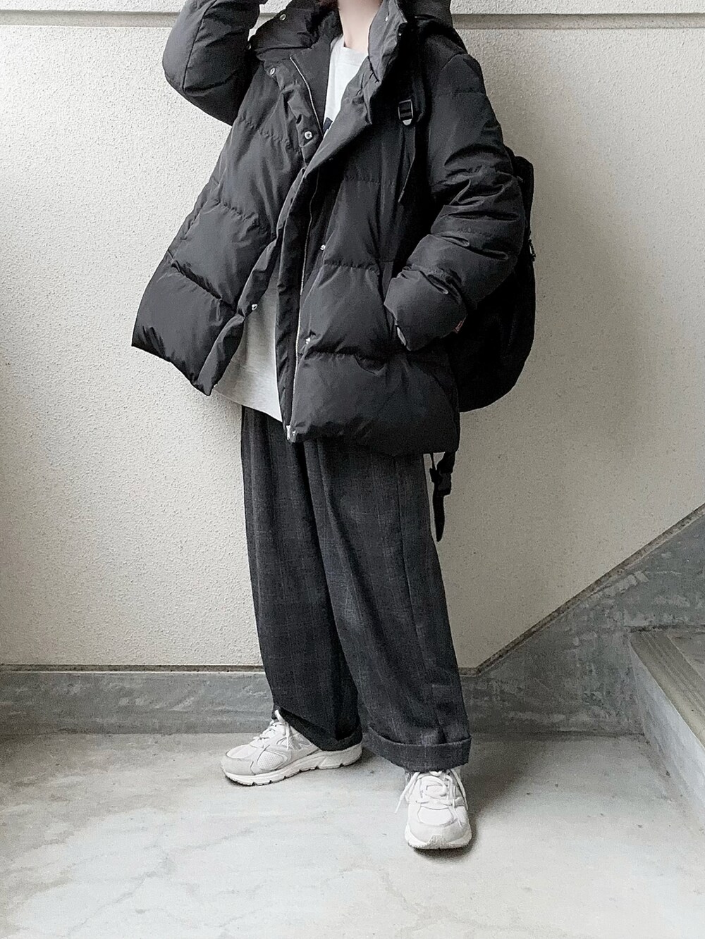 ブラック系のダウンジャケット/コート、ベージュ系のスウェット、グレー系のスラックスを着用したレディースの冬コーディネートの3枚目の写真