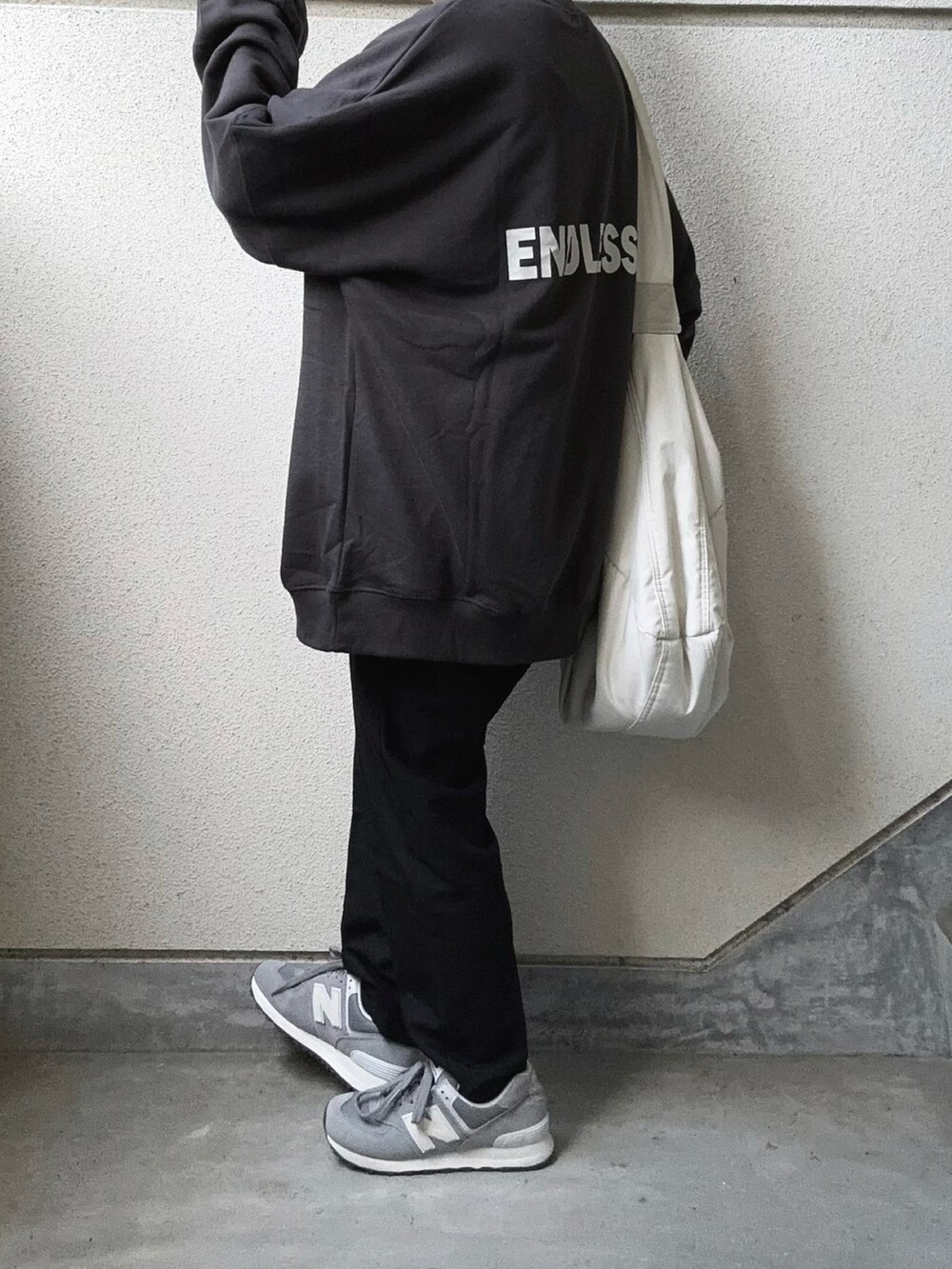 グレー系のスウェット、ブラック系のその他パンツ、ホワイト系のショルダーバッグを着用したレディースの秋コーディネートの3枚目の写真