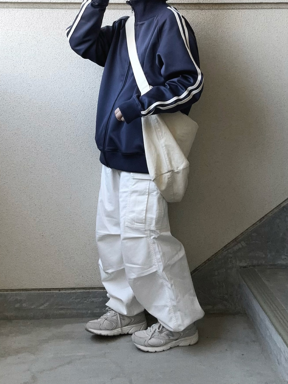 ホワイト系のカーゴパンツ、ブルー系のジャージ、グレー系のスニーカーを着用したレディースの春コーディネートの4枚目の写真