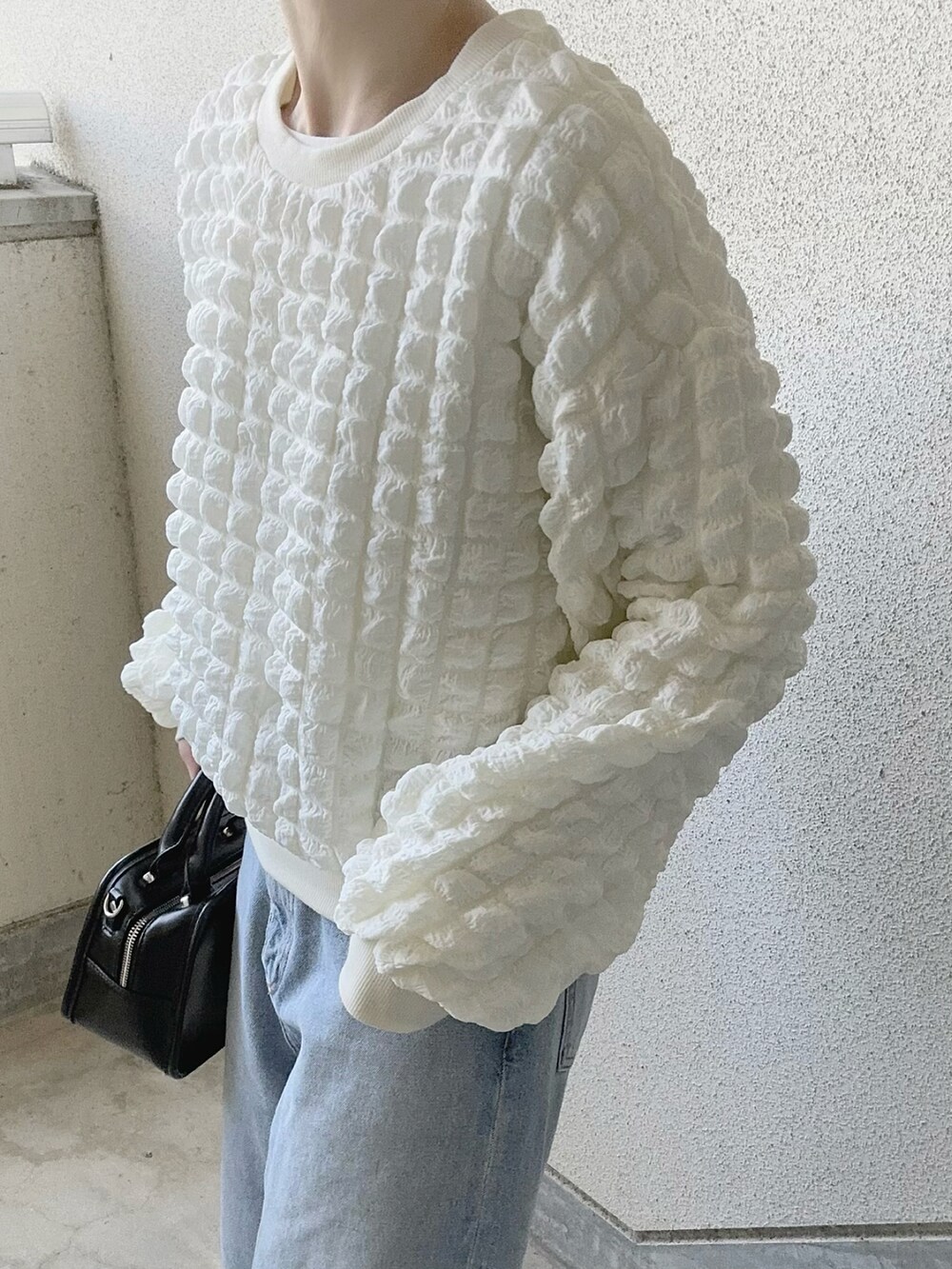 ホワイト系のTシャツ/カットソー、ブルー系のデニムパンツ、ブラック系のスニーカーを着用したレディースの冬コーディネートの3枚目の写真