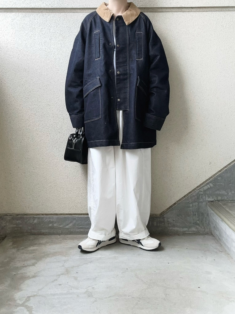 ブルー系のデニムジャケット、ホワイト系のチノパンツ、ベージュ系のスニーカーを着用したレディースの秋コーディネートの4枚目の写真