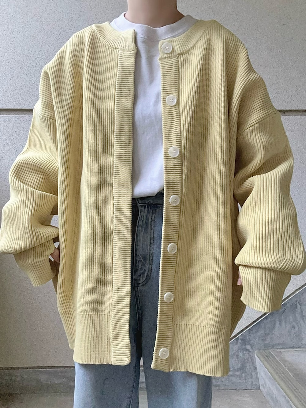 イエロー系のカーディガン/ボレロ、ホワイト系のショルダーバッグを着用したレディースの冬コーディネートの4枚目の写真