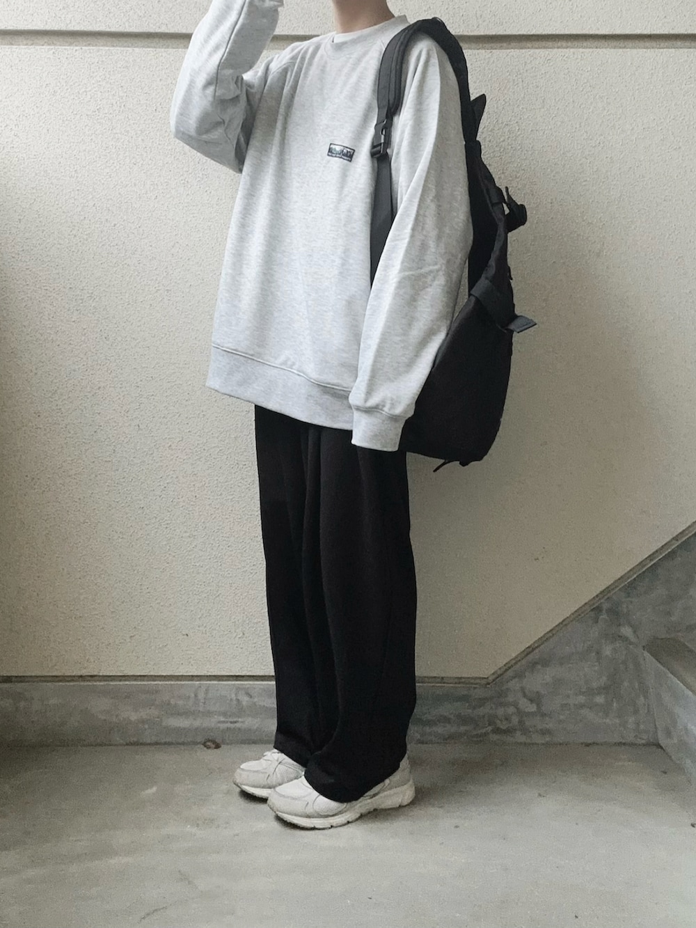 グレー系のスウェット、ブラック系のボディバッグ/ウエストポーチ、ブラック系のスラックスを着用したレディースの冬コーディネートの3枚目の写真