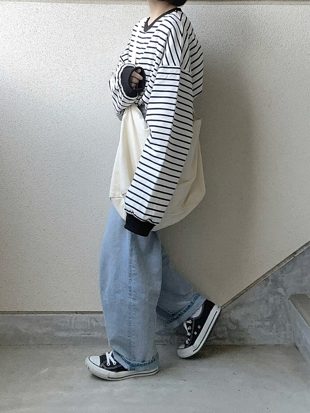 ブラック系のTシャツ/カットソー、ブルー系のデニムパンツ、ホワイト系のショルダーバッグを着用したレディースの春コーディネートの4枚目の写真