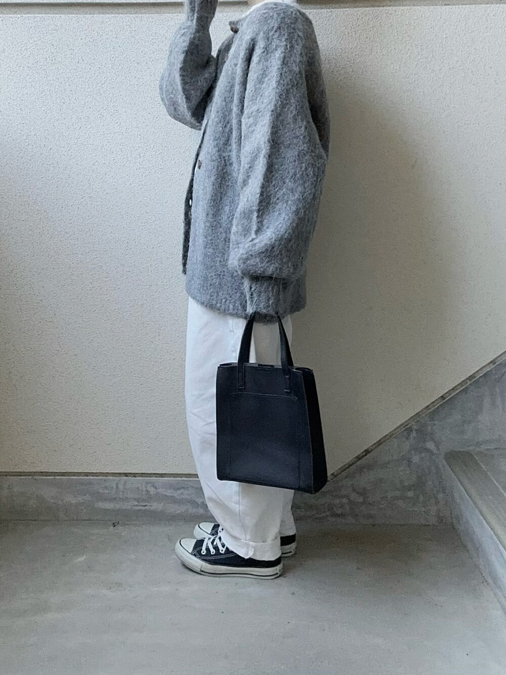 ブラック系のカーディガン/ボレロ、ブラック系のショルダーバッグ、ホワイト系のデニムパンツを着用したレディースの冬コーディネートの3枚目の写真