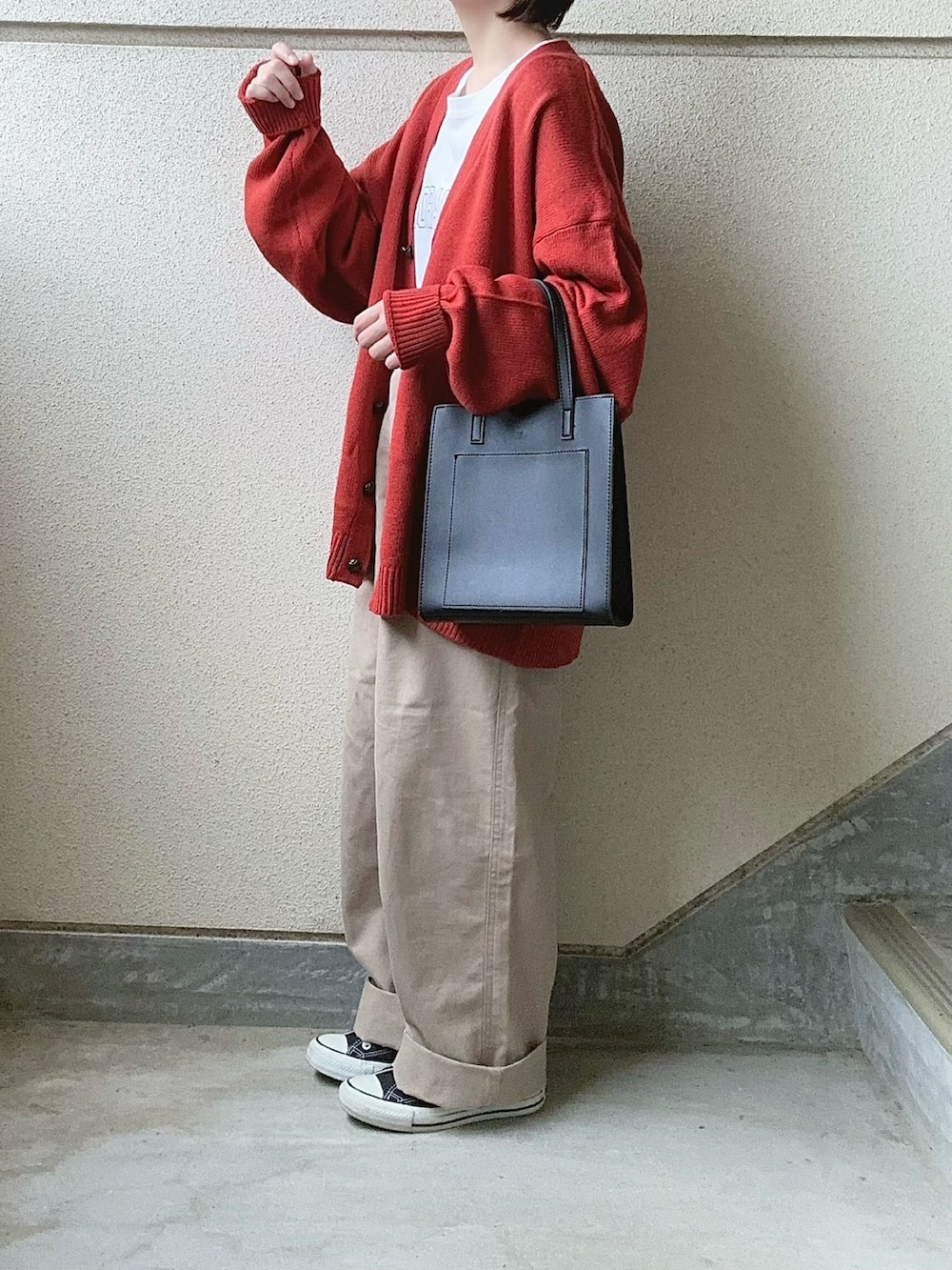 オレンジ系のカーディガン/ボレロ、ホワイト系のTシャツ/カットソー、ベージュ系のその他パンツを着用したレディースの冬コーディネートの4枚目の写真