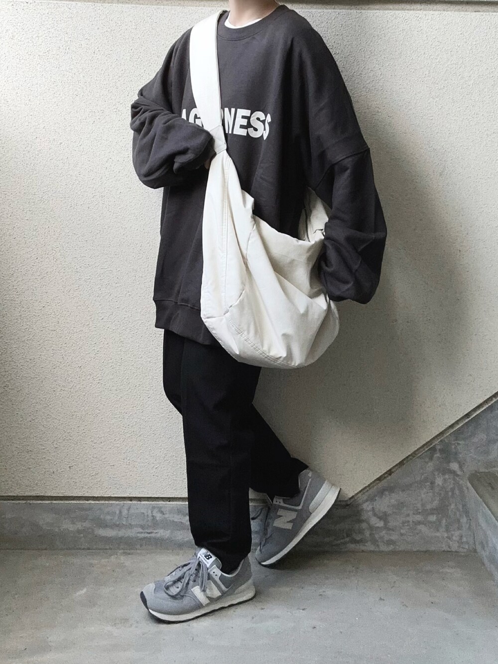 グレー系のスウェット、ブラック系のその他パンツ、ホワイト系のショルダーバッグを着用したレディースの秋コーディネートの2枚目の写真