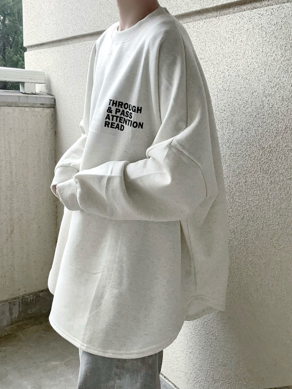 ベージュ系のスウェット、グレー系のデニムパンツ、グレー系のスニーカーを着用したレディースの冬コーディネートの4枚目の写真