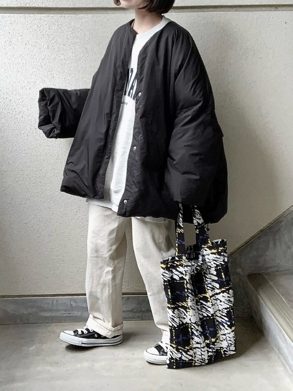 ブラック系のその他アウター、ベージュ系のスウェット、ホワイト系のデニムパンツを着用したレディースの冬コーディネートの2枚目の写真