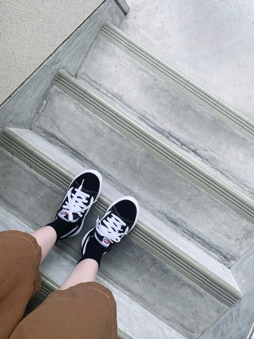 ブラック系のベスト、ブラック系のスニーカー、ブラウン系のその他パンツを着用したレディースの秋コーディネートの4枚目の写真