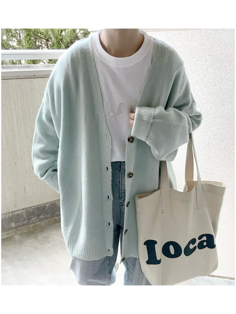 ブルー系のカーディガン/ボレロ、ホワイト系のTシャツ/カットソーを着用したレディースの冬コーディネートの4枚目の写真