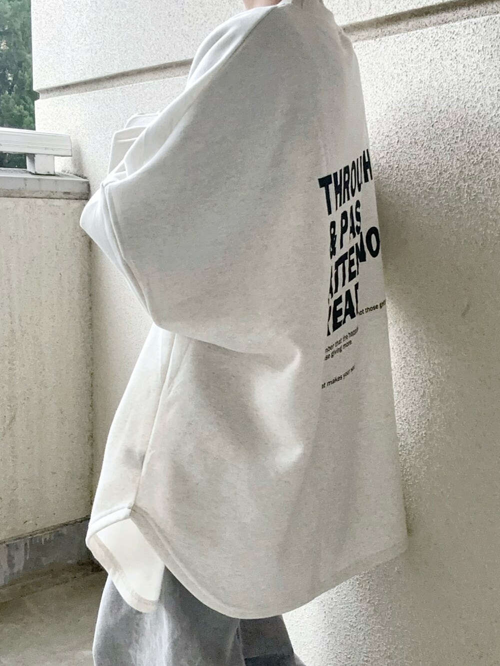 ベージュ系のスウェット、グレー系のデニムパンツ、グレー系のスニーカーを着用したレディースの冬コーディネートの2枚目の写真