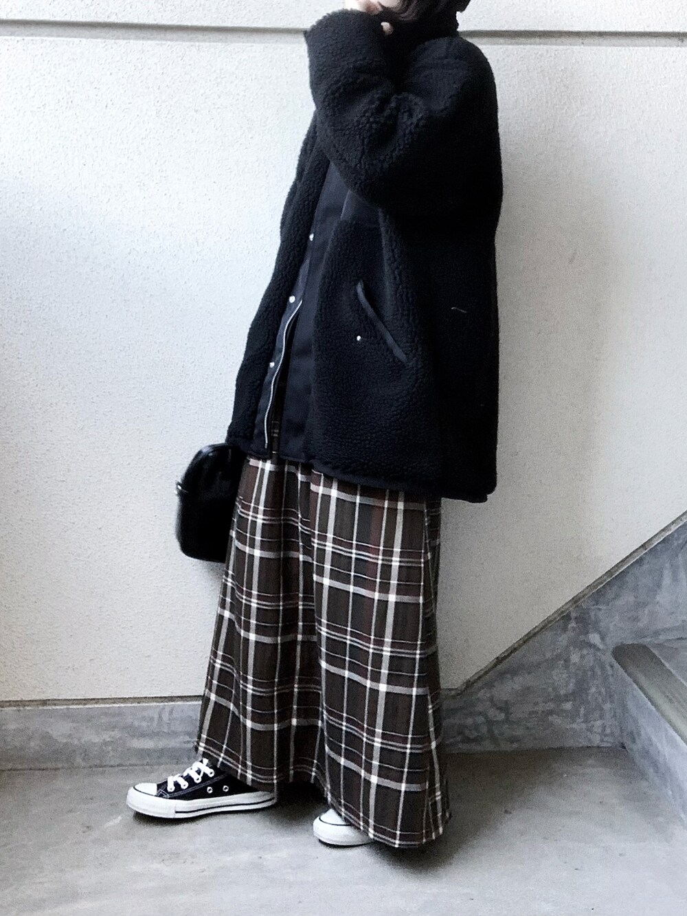 ブラック系のブルゾン、グリーン系のスカート、ホワイト系のニット/セーターを着用したレディースの冬コーディネートの2枚目の写真