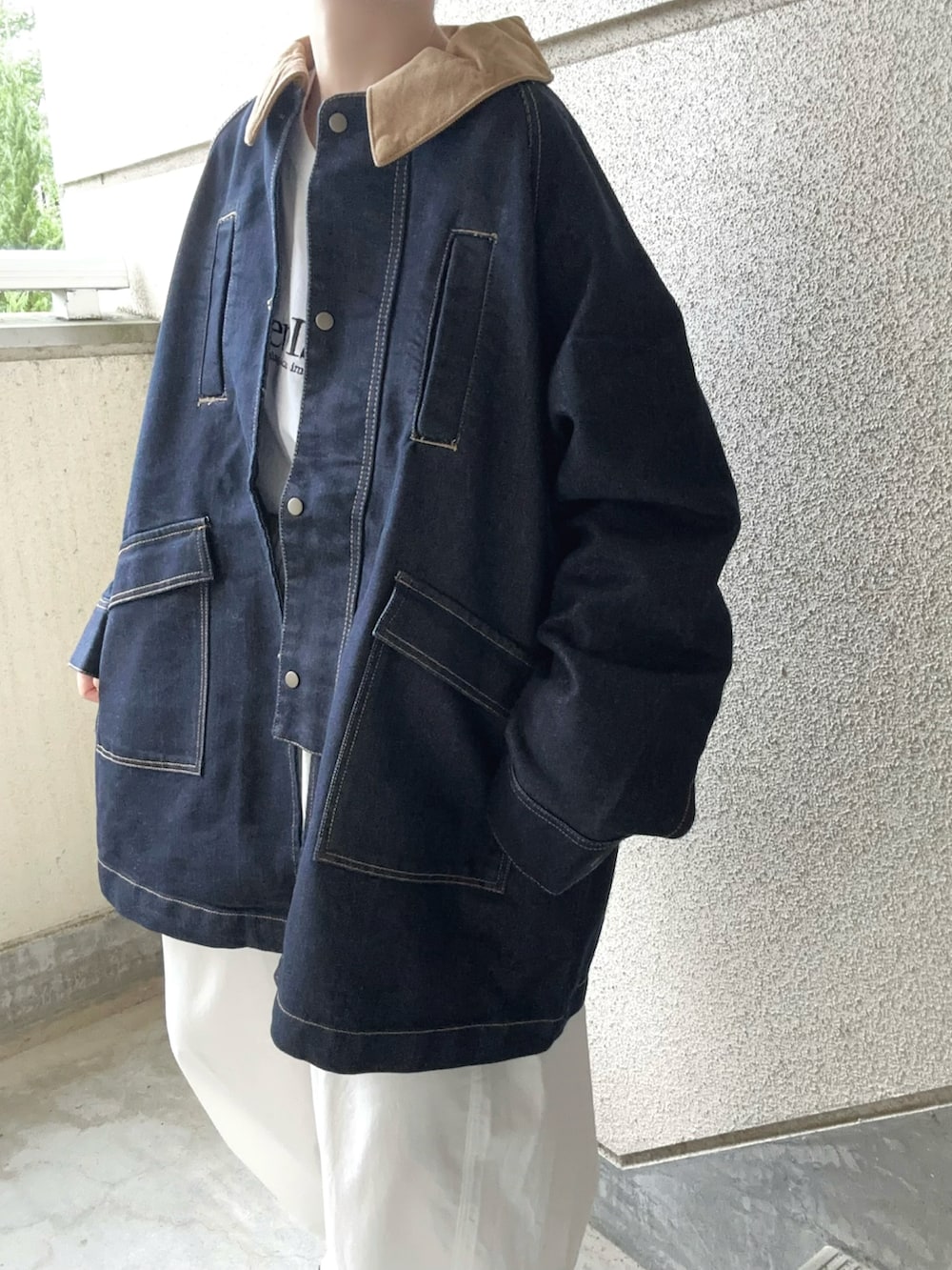 ブルー系のデニムジャケット、ホワイト系のチノパンツ、ベージュ系のスニーカーを着用したレディースの秋コーディネートの3枚目の写真