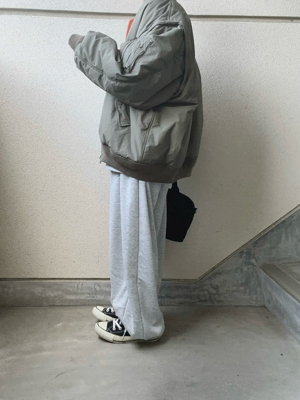 グレー系のスウェットパンツ、グレー系のスウェット、グリーン系のMA-1を着用したレディースの冬コーディネートの2枚目の写真