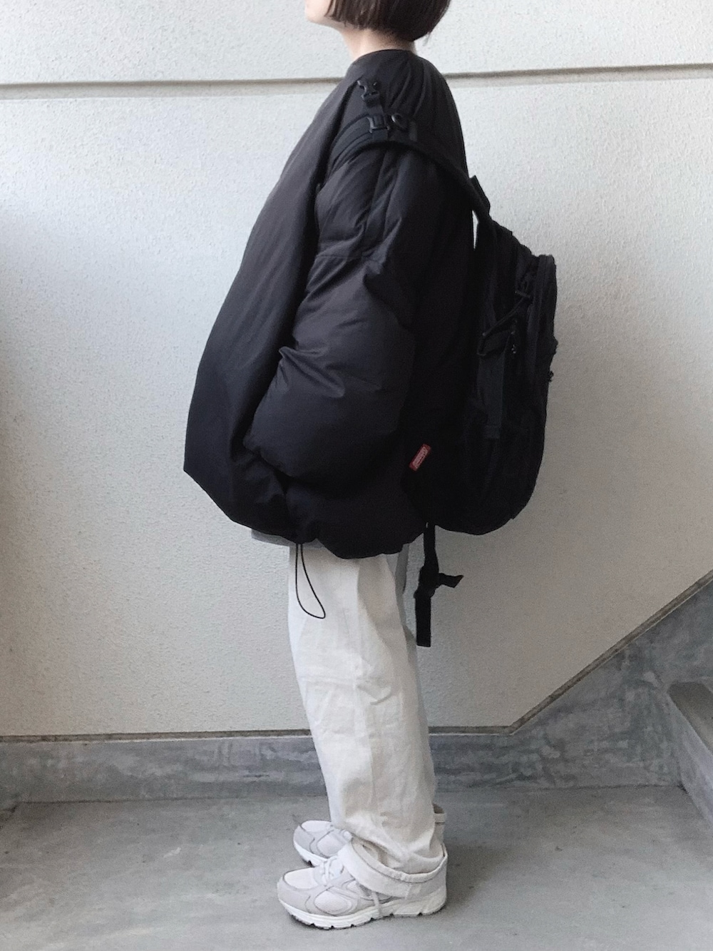 ブラック系のその他アウター、グレー系のスウェット、ホワイト系のデニムパンツを着用したレディースの冬コーディネートの2枚目の写真