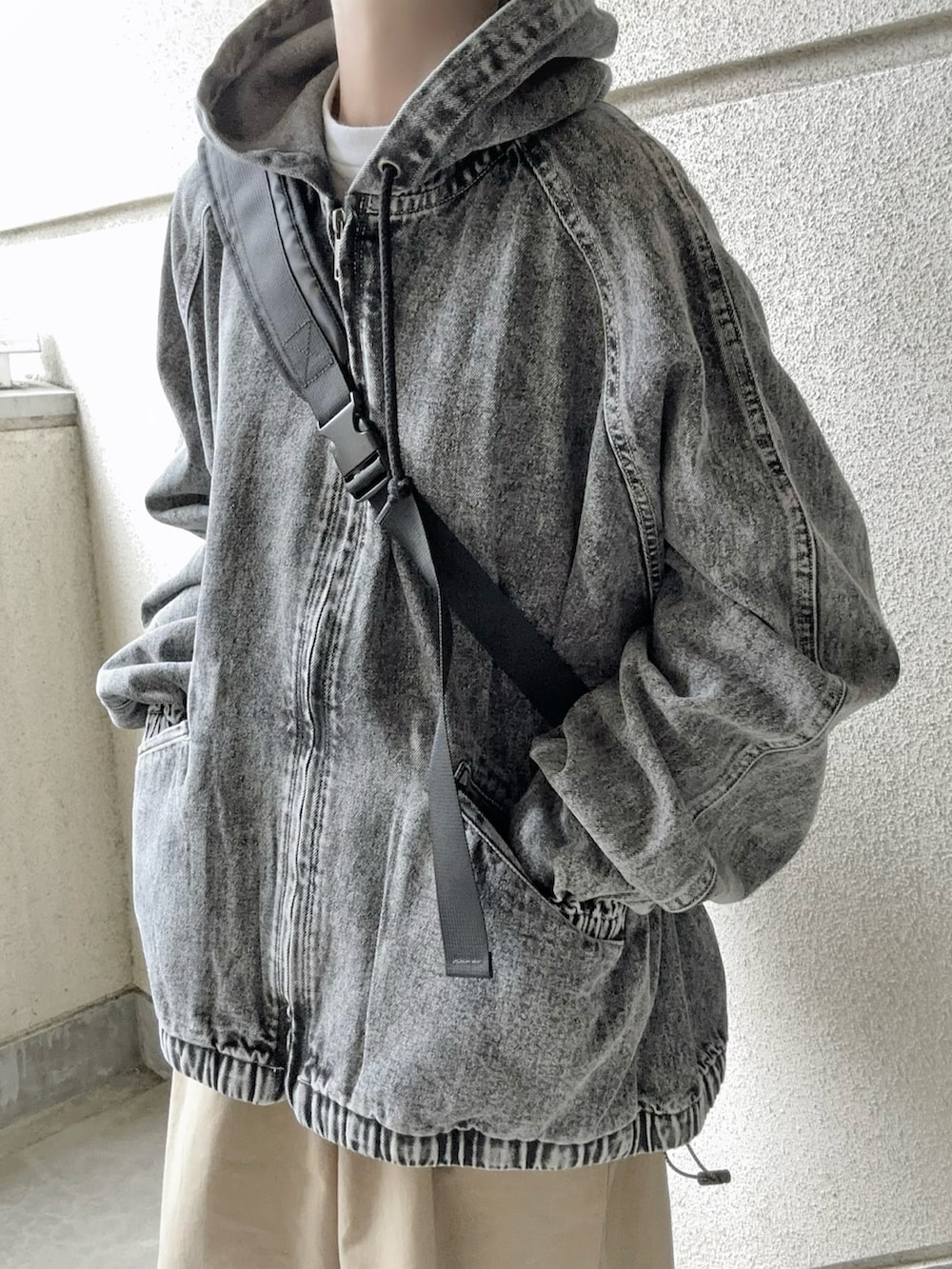 ブラック系のブルゾン、ベージュ系のチノパンツ、ブラック系のボディバッグ/ウエストポーチを着用したレディースの春コーディネートの3枚目の写真