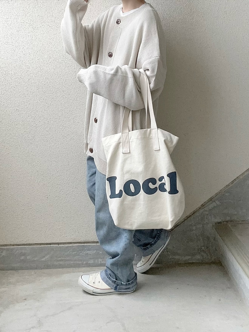 ベージュ系のカーディガン/ボレロ、ブルー系のデニムパンツ、ホワイト系のスニーカーを着用したレディースの冬コーディネートの4枚目の写真