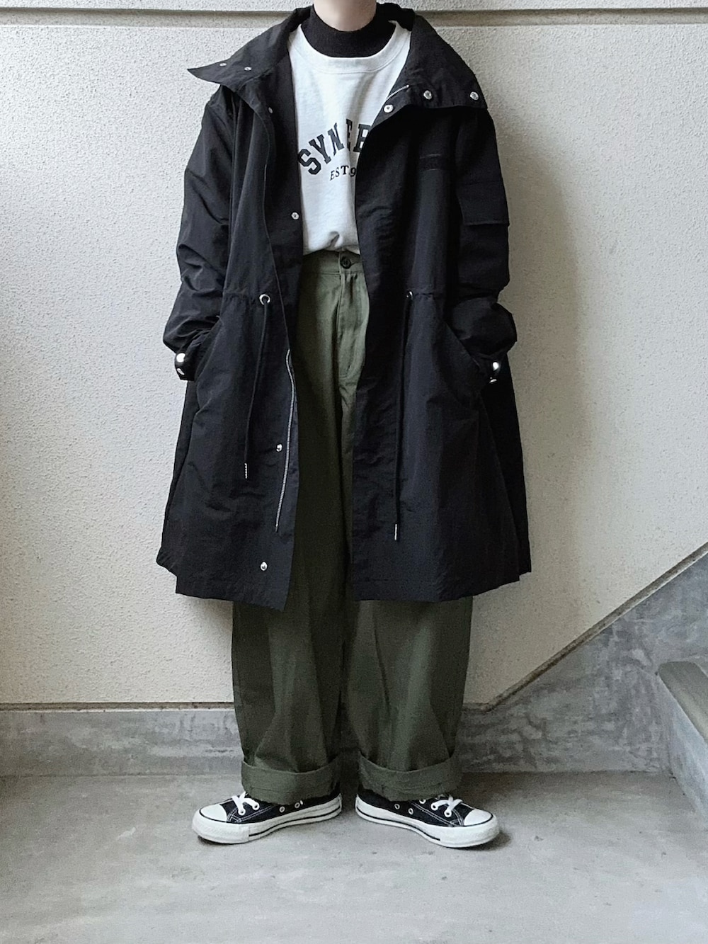 ブラック系のモッズコート、グリーン系のカーゴパンツ、ブラック系のニット/セーターを着用したレディースの秋コーディネートの5枚目の写真