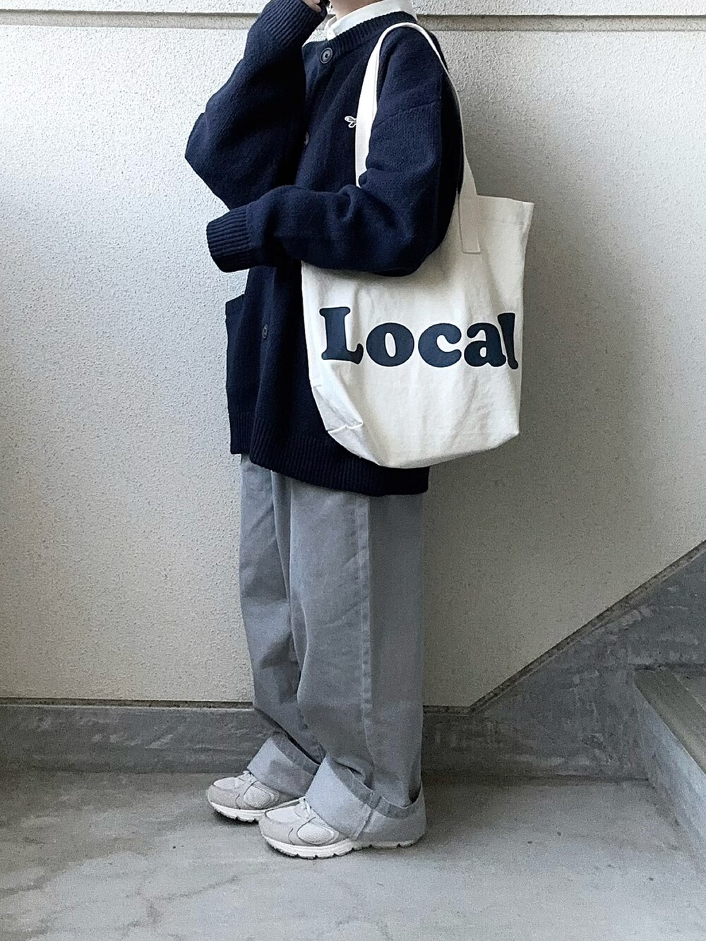 グレー系のデニムパンツ、ブルー系のカーディガン/ボレロ、ホワイト系のシャツ/ブラウスを着用したレディースの冬コーディネートの3枚目の写真