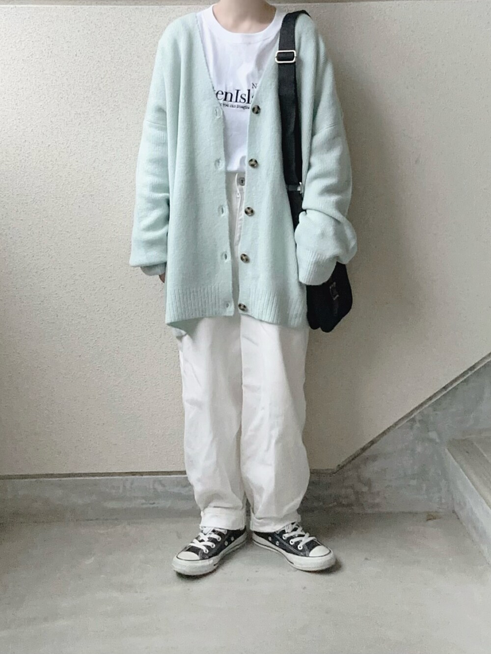 ブルー系のカーディガン/ボレロ、ホワイト系のTシャツ/カットソー、ブラック系のショルダーバッグを着用したレディースの冬コーディネートの2枚目の写真