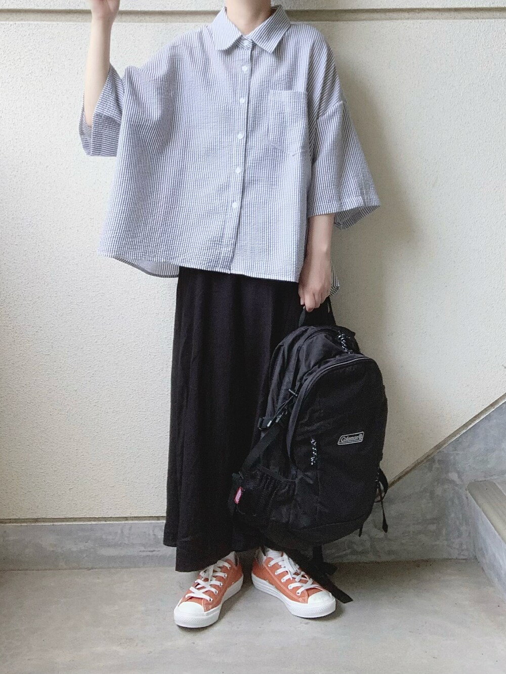 ブラック系のスカート、ブラック系のシャツ/ブラウス、オレンジ系のスニーカーを着用したレディースの夏コーディネートの3枚目の写真