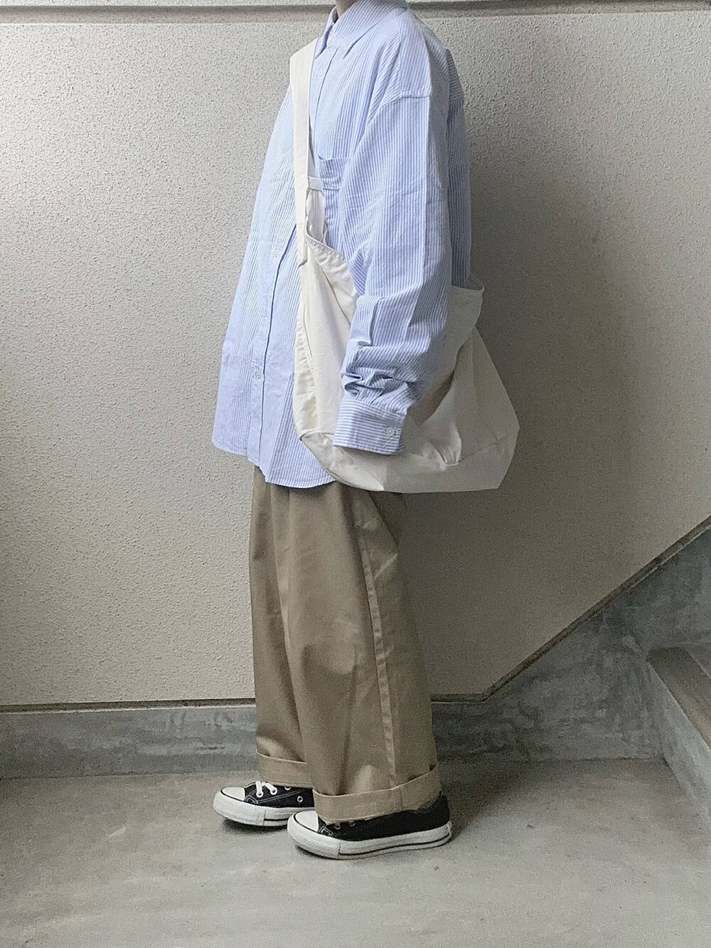 ブルー系のシャツ/ブラウス、ベージュ系のチノパンツ、ホワイト系のショルダーバッグを着用したレディースの冬コーディネートの4枚目の写真