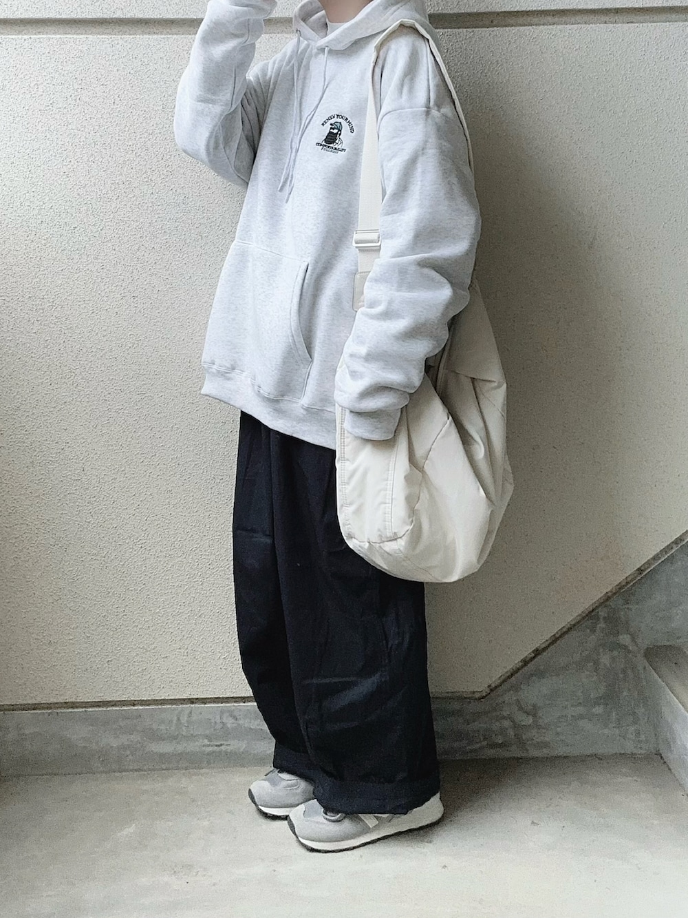 グレー系のパーカー、ブルー系のチノパンツを着用したレディースの春コーディネートの3枚目の写真