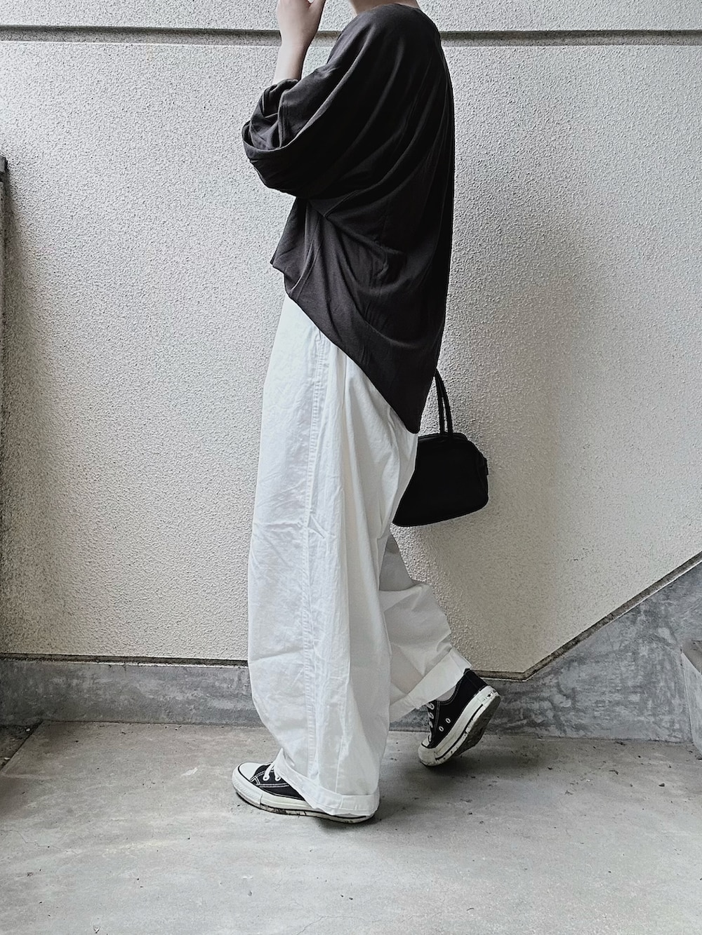 ブラック系のTシャツ/カットソー、ホワイト系のチノパンツを着用したレディースの夏コーディネートの3枚目の写真