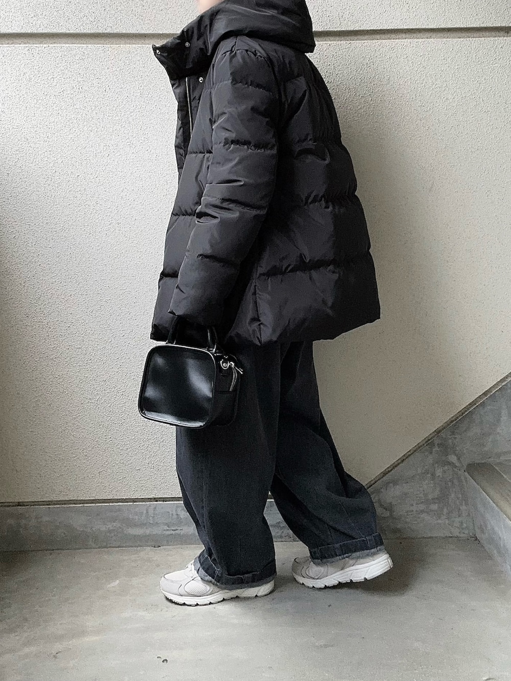 ホワイト系のスウェット、ブラック系のダウンジャケット/コート、グレー系のデニムパンツを着用したレディースの冬コーディネートの3枚目の写真