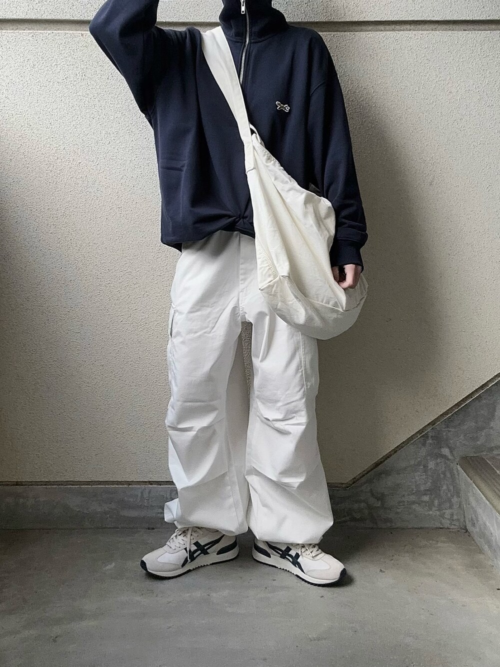 ホワイト系のカーゴパンツ、ブルー系のスウェット、ホワイト系のショルダーバッグを着用したレディースの冬コーディネートの2枚目の写真