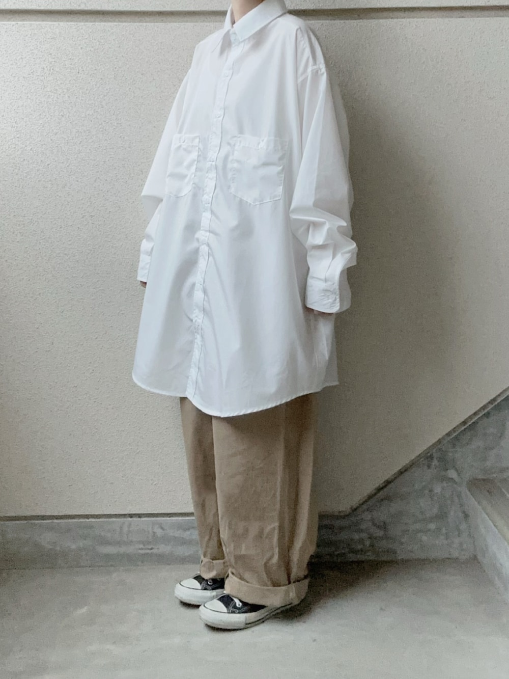 ホワイト系のシャツ/ブラウス、ベージュ系のチノパンツ、ブラック系のショルダーバッグを着用したレディースの冬コーディネートの4枚目の写真