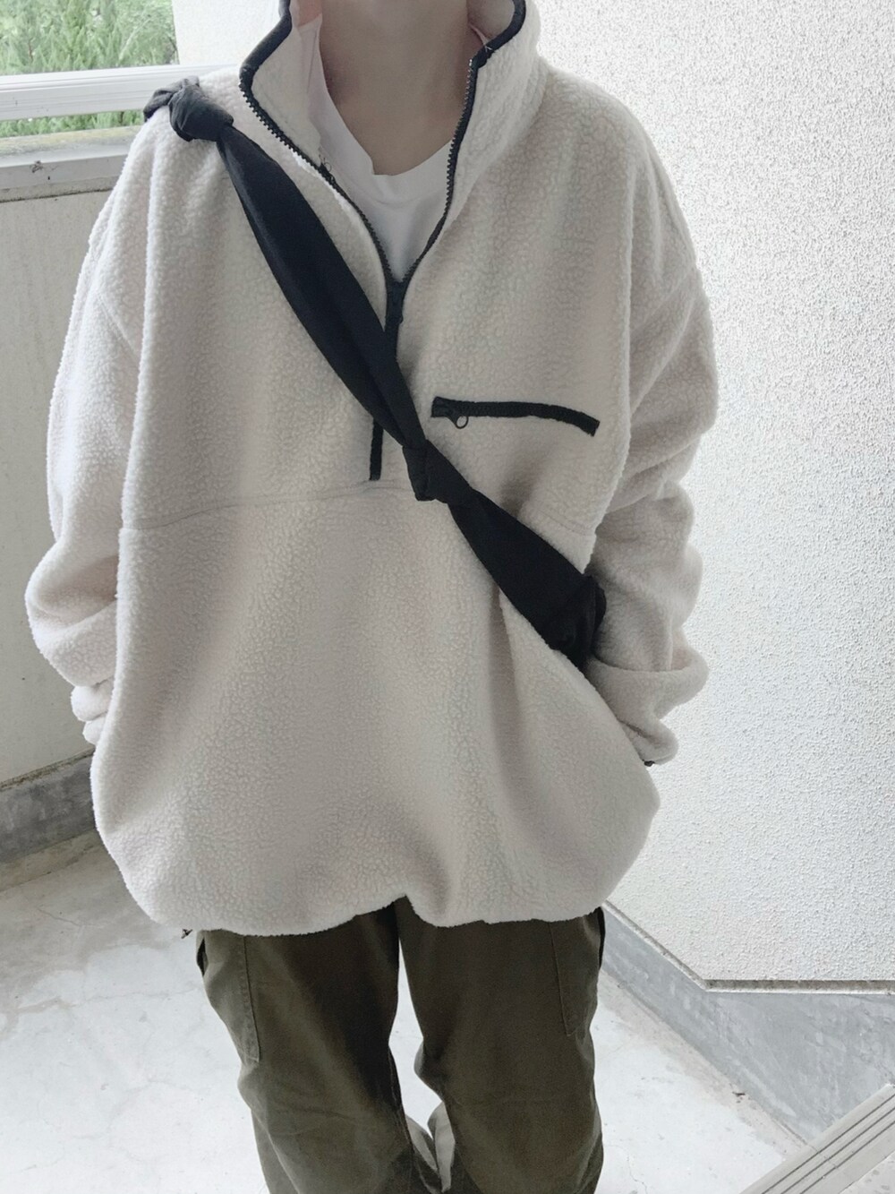 ホワイト系のスウェット、グリーン系のカーゴパンツ、ブラック系のショルダーバッグを着用したレディースの秋コーディネートの5枚目の写真