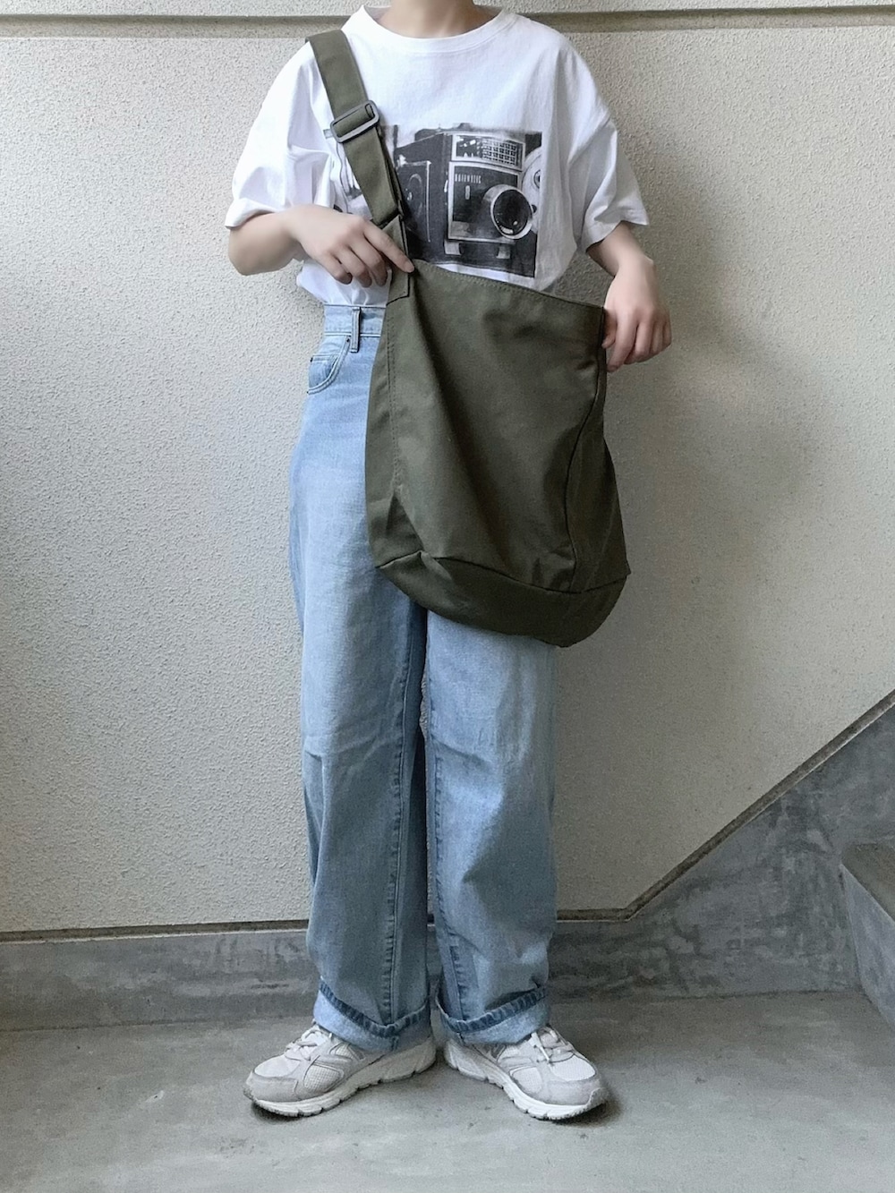 ブラック系のTシャツ/カットソー、グリーン系のショルダーバッグを着用したレディースの夏コーディネートの2枚目の写真